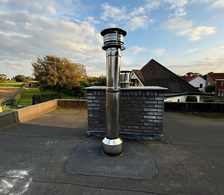 Rvs rookkanaal met kap op een plat dak