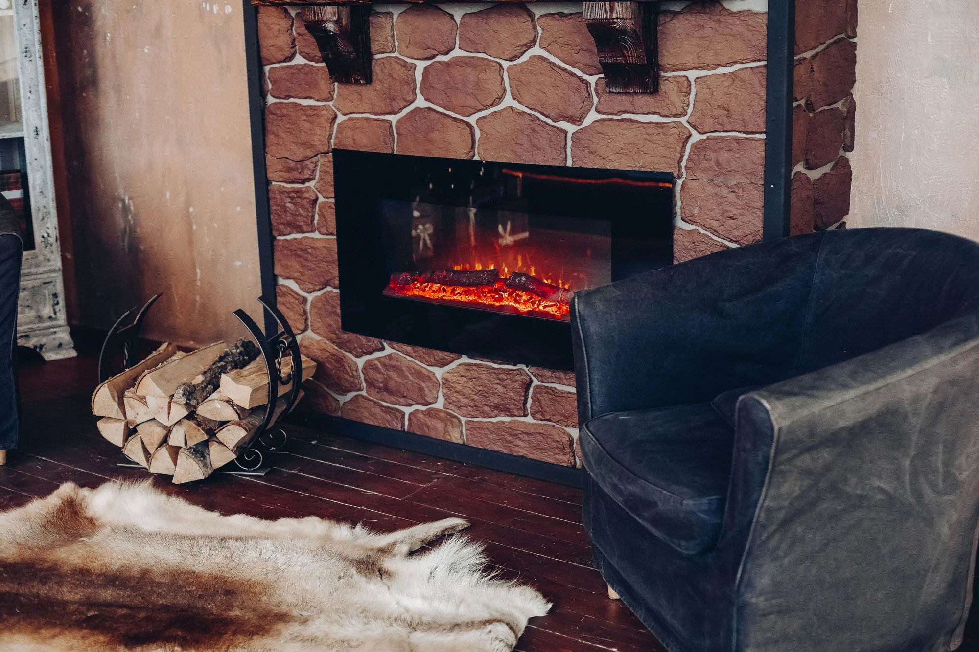 Sfeerhaard in een stenen wand met een houtmand en een fauteuil