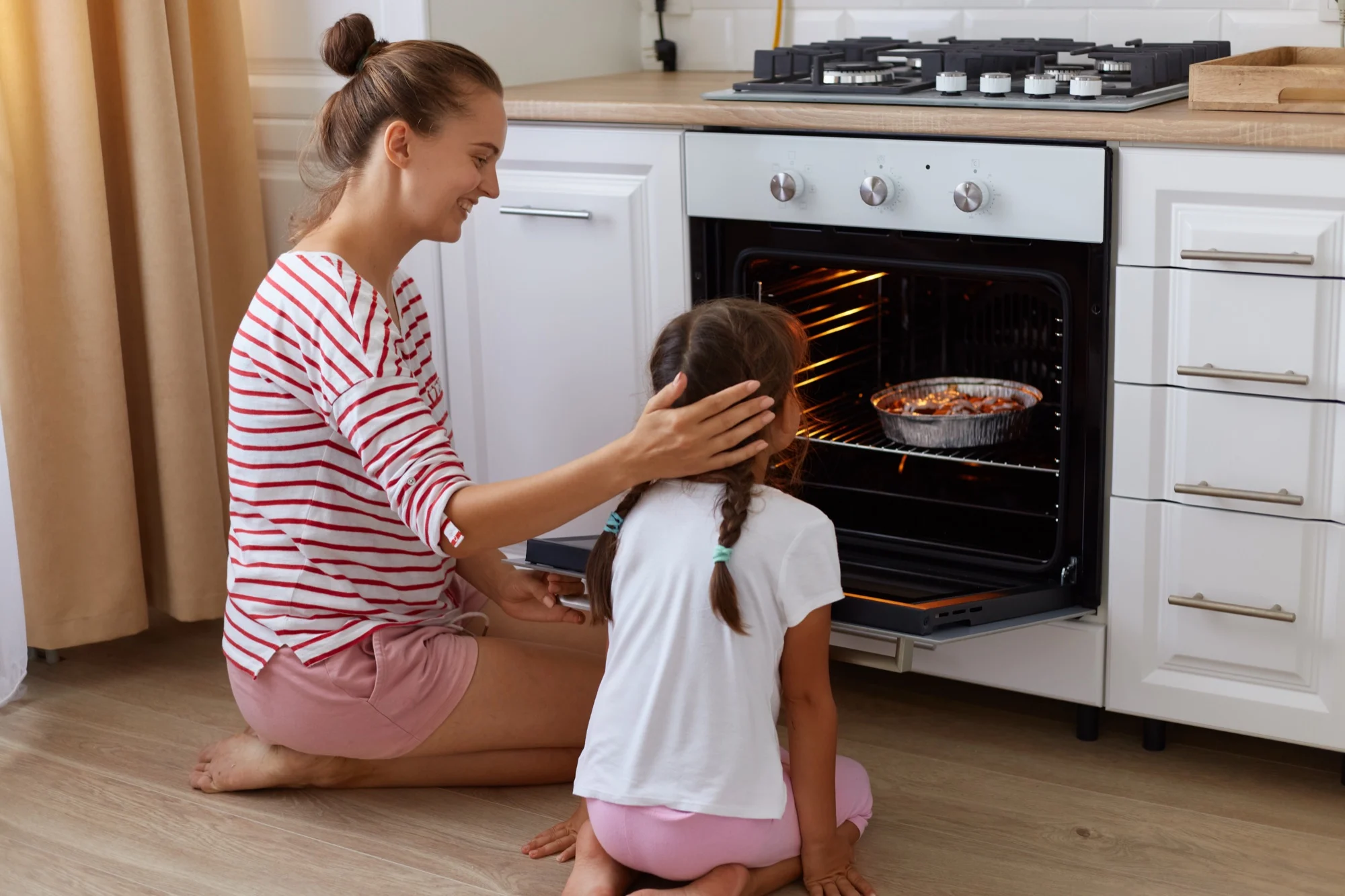 Moeder en dochter kijken in de oven
