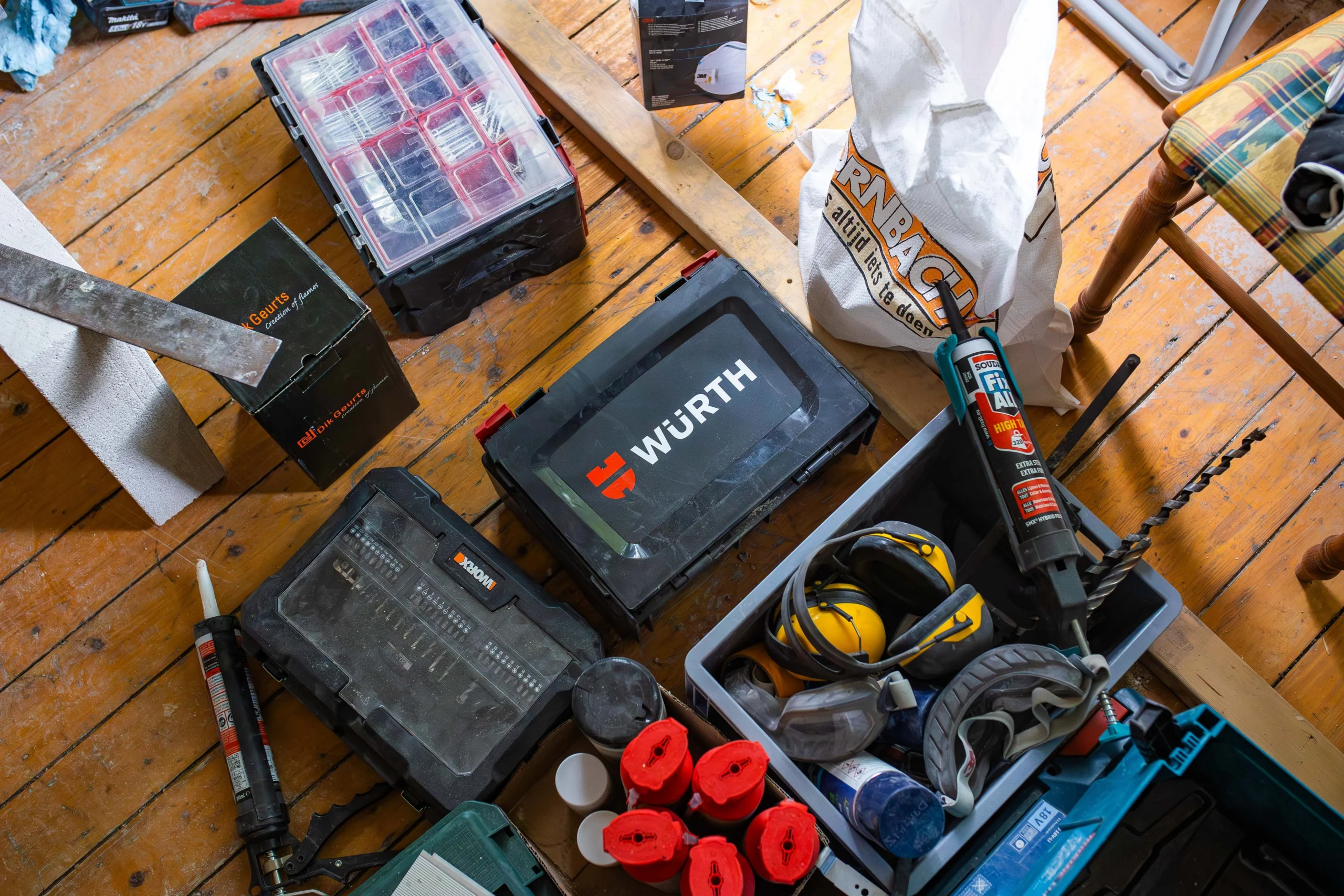 Gereedschapskoffers en materiaal op een houten vloer
